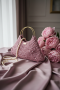 Borsa crochet lilla su sfondo velluto con bokeh dorati